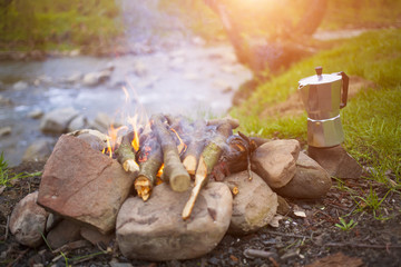 The fire in the clearing near the river.