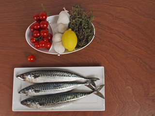 Mackerel on a plate and a plate with vegetables.