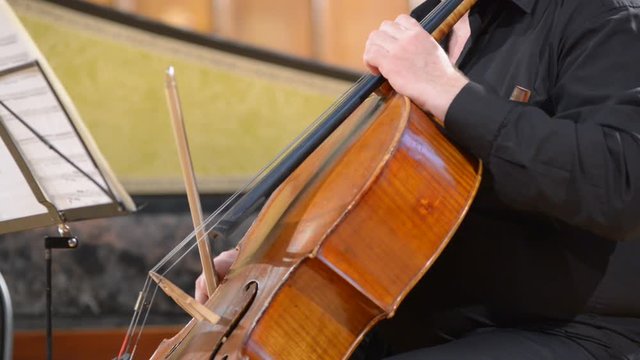 Cellist playing cello, blurred defocused background