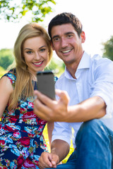 Paar macht Selfie mit Handy im Park