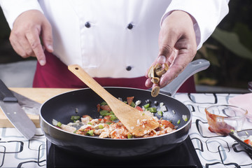 Chef putting mushroom to the pan