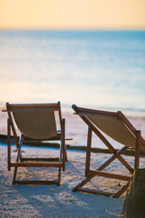 Beach chairs at beautiful tropical resort in sunset