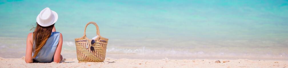 Young beautiful girl relaxing on white beach. Tourist woman enjoy beach vacation lying on the sand