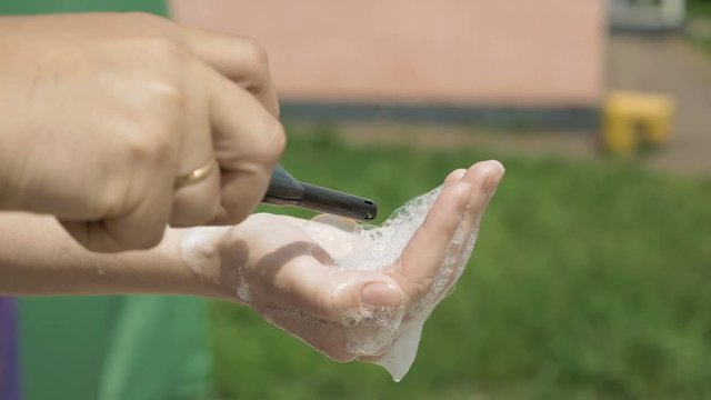 A hand with soapy water mixed with flammable substance is set on fire with a lighter. It is a risky stunt but fun to witness. An experiment can be shown in lab and classrooms. 4K UHD video footage.