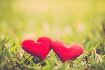 Red valentine hearts on green grass background. vintage filter