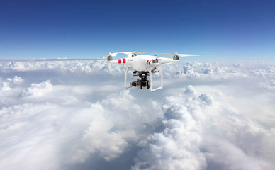 Fototapeta na wymiar Flying drone quadcopte over the white cloud