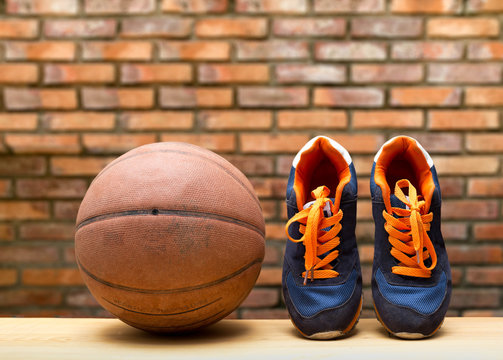 Pair of sport shoes and basketball ball