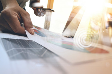 business man hand working on laptop computer with digital layer