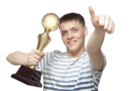 Man holding up a gold trophy cup as a winner in a competition is