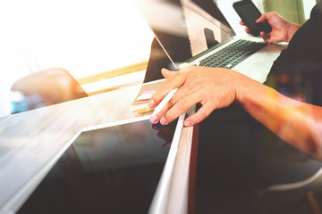 designer hand working and smart phone and blank screen laptop an