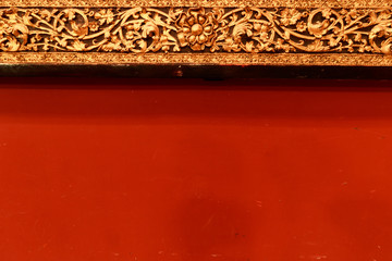 Old wood carving on the wall temple in Myanmar. Myanmar temple carving on red wall.