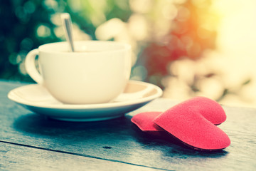 Morning hot coffee with love heart on table in fresh garden. vintage filter
