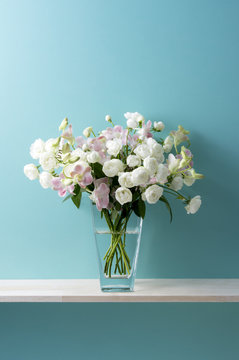 青い背景と白い薔薇とピンクのデンファレと花瓶