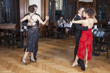 Dancers Performing Tango While Couple Dating In Restaurant