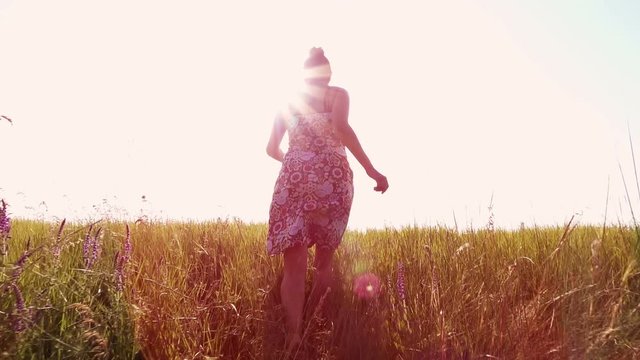 Slow motion video - woman running on the field away from camera. Full HD people stock footage.  
