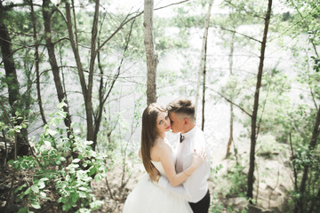 Kissing wedding couple staying over beautiful landscape