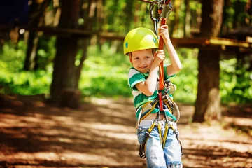 Gardinen Adventure climbing high wire park - little child on course in mountain helmet and safety equipment © Volha Zaitsava
