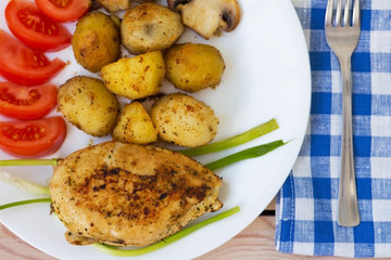 fried chicken fillet with potatoes tomatoes and mushrooms