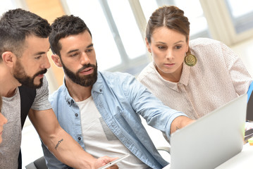 Design team meeting and working on laptop