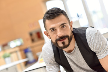 Obraz premium Portrait of cheerful trendy bearded guy in office