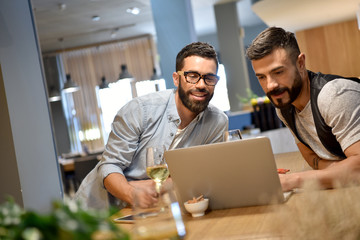 Trendy guys in bar connected with laptop