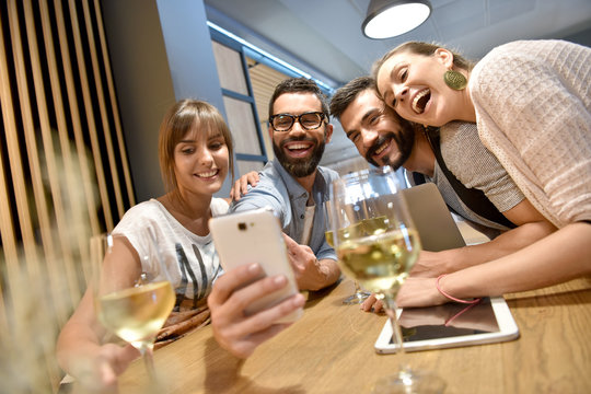 Group of friends taking selfie pictures in bar