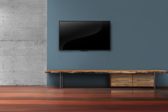 Led tvs on dark blue wall with wooden furniture in empty living room