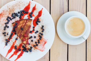 cherry pie with blueberries and coffee on a wooden background