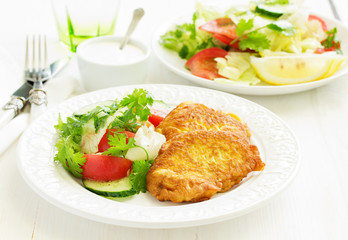 Pork chop in batter with vegetable salad.
