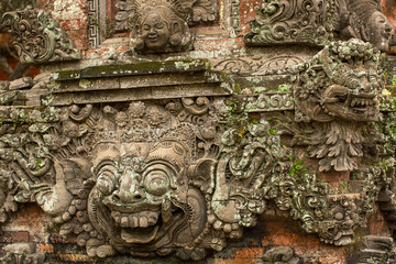 Traditional demon guards statue carved in stone on Bali island.