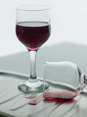 A couple of wine glasses, one of them fell.