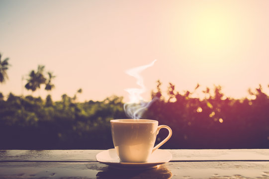 Hot coffee on sunrise background