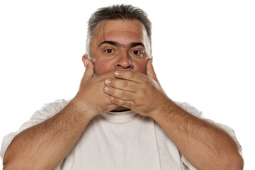 a fat man covering his mouth with his hands