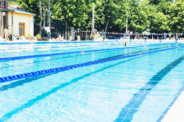 Swimming lanes with clear blue water in public swimming pool in summer 