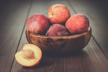 Fototapeta na wymiar wooden bowl with some peaches on brown table
