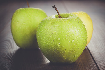 fresh green apples on the brown wooden table
