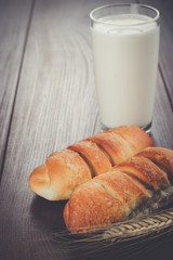 glass of milk and buns on the table