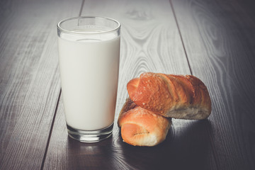 glass of milk and fresh buns on the table