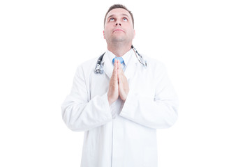 Male doctor posing in praying position like hoping