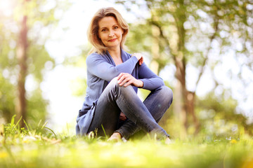 Frau im besten Alter sitzt in der Natur