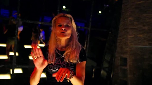 Attractive young woman dancing in a nightclub on a dancefloor