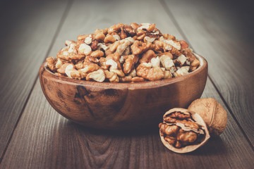 walnuts in the brown wooden bowl on table