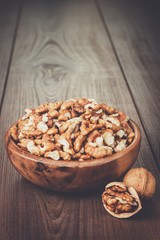 walnuts in the brown wooden bowl on table