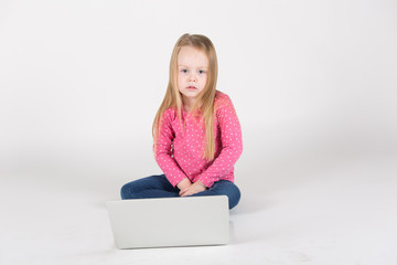 Naklejka premium Kleines Mädchen / Heranwachsende sitzt frontal vor Laptop