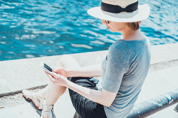 Single young woman with hat at riverfront