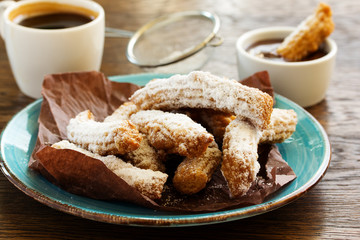 Churros with hot chocolate and powdered sugar.
