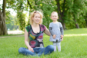 Beautiful young woman with her baby in the park.