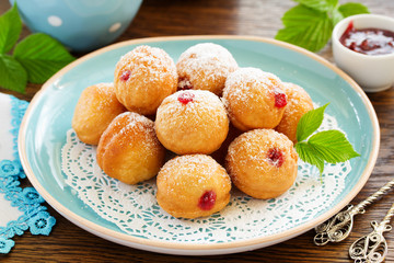 Donuts filled with raspberry jam and powdered sugar in.