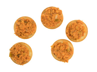 Spicy chicken salad on butter crackers top view isolated on a white background.