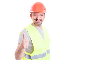 Cheerful handsome engineer with helmet doing thumb up gesture